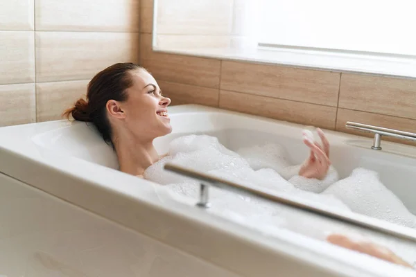 Bien sûr se trouve dans la baignoire Mousse blanche peau claire sourire de relaxation — Photo