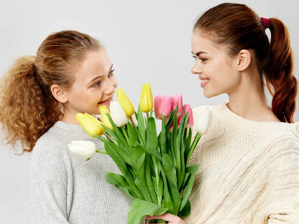 Mãe e filha com um buquê de flores tulipas aniversário surpresa feriado — Fotografia de Stock