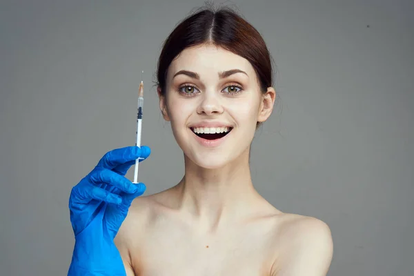 Kvinna i blå handskar med spruta i hand med botox injektion behandling mot rynkor — Stockfoto