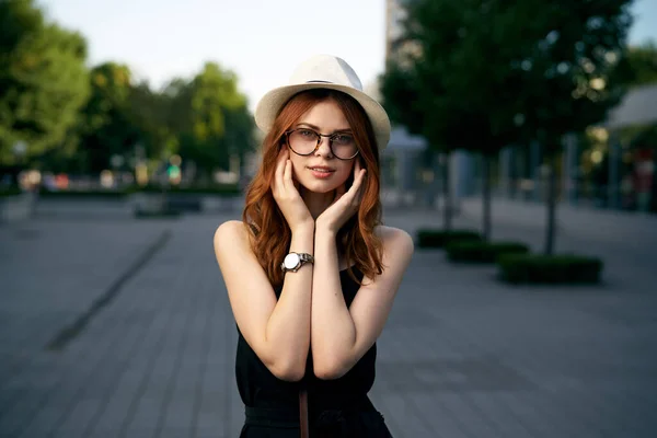 Donna alla moda sulla strada della città in abito nero e cappello occhiali trucco modello orologio a portata di mano aria fresca — Foto Stock