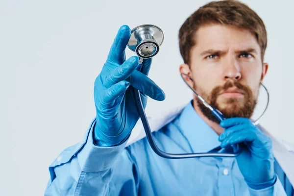 Homem de vestido médico assistente de laboratório com líquido em frasco e estetoscópio médico reação química luz fundo — Fotografia de Stock