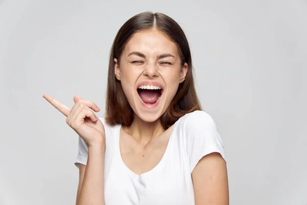 Mulher feliz em t-shirt branca mostra polegar para o lado Copiar espaço rindo emoções — Fotografia de Stock