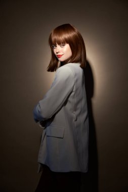 Akşamları şık giyinen kadın elleriyle jestler yapar.