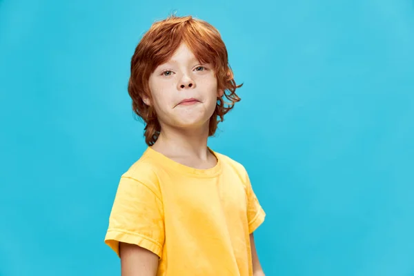 バカな顔の赤い髪の黄色いTシャツの男の子 — ストック写真