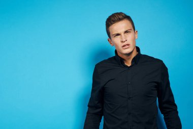 Siyah gömlekli duygusal adam stüdyo tarzı mavi izole edilmiş arka plan