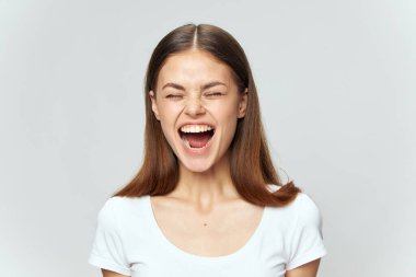 Mutlu kadın ağzı açık, gözleri kapalı, beyaz tişörtlü, eğlenceli. 