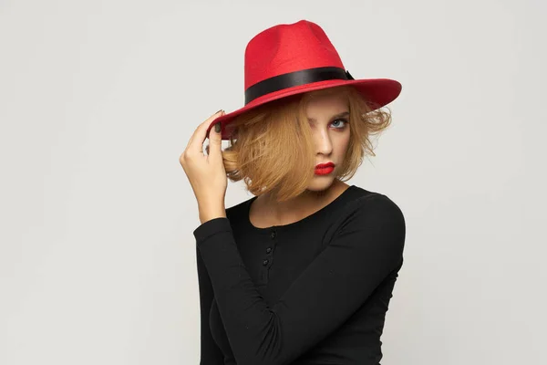 Fashionabel kvinna i röd hatt svart blus röda läppar beskärda visa ljus bakgrund känslor — Stockfoto