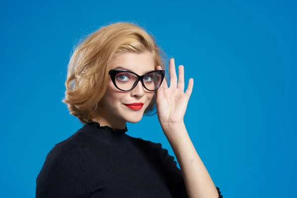 Blond mit kurzen Haaren rote Lippen Brille schwarze Jacke blau isolierter Hintergrund — Stockfoto
