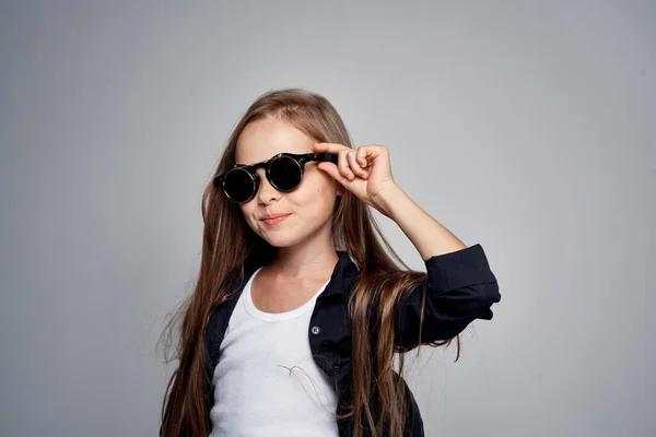 Cute uczennica noszenie okularów słonecznych dzieciństwo nauka szkoły lekkie tło — Zdjęcie stockowe