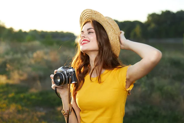Wanita tersenyum berpegangan tangan pada kamera topi alam udara segar — Stok Foto