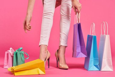 Alışveriş torbaları ayakkabılı kadın ayakları Alışveriş kolik pembe arka plan