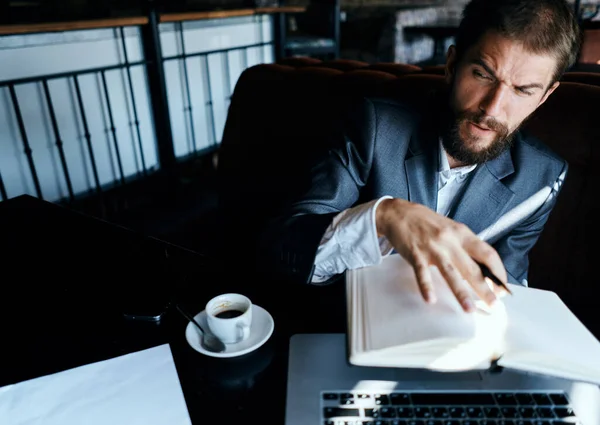 Uomo d'affari seduto in un caffè di fronte a un computer portatile con una tazza di caffè lavoro tecnologia stile di vita — Foto Stock