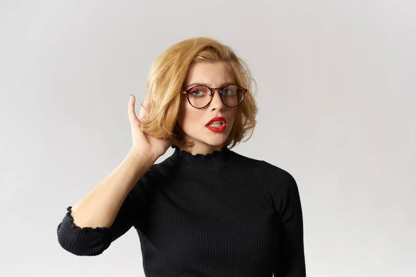 Blondes Mädchen mit Brille rote Lippen schwarze Bluse ausgeschnitten Ansicht Glamour Licht Hintergrund Studio — Stockfoto
