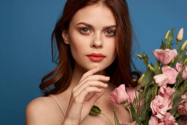 Piękna kobieta z bukietem różowych kwiatów na niebieskim tle model wiosna — Zdjęcie stockowe