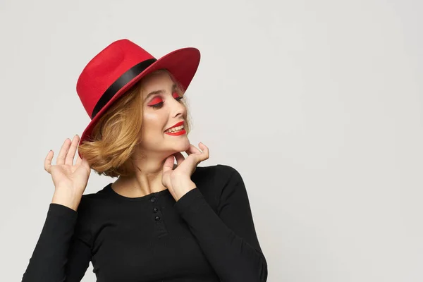빨간 모자를 쓰고 붉은 입술을 하고 있는 유행적 인 여자가 밝은 배경 감정을 보고 있다 — 스톡 사진