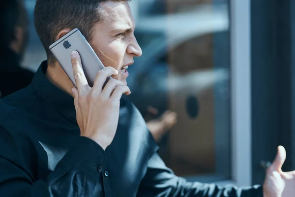 Geschäftsmann im schwarzen Hemd telefoniert im Freien — Stockfoto