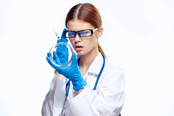 Médico mulher em luvas azuis com estetoscópio enfermeira com óculos injeção seringa laboratório luz fundo — Fotografia de Stock