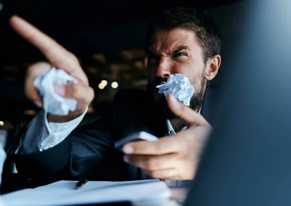 Biznesmen siedzi przy stole przed laptopem zgnieciony papier styl życia wykonawczej technologii pracy — Zdjęcie stockowe