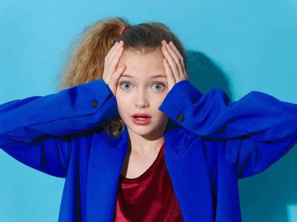 Überraschtes Mädchen hält den Kopf in blauem Mantel — Stockfoto