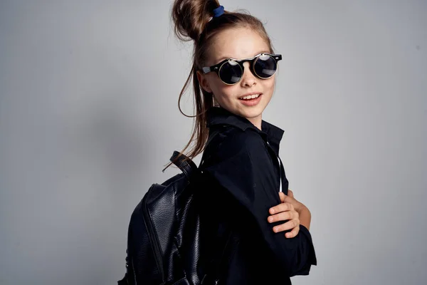 Söt skolflicka bär solglasögon barndom lärande skola ljus bakgrund — Stockfoto