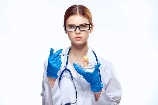 Врач женщина в синих перчатках со стетоскопом медсестра с очками инъекции шприц лабораторный свет фон — стоковое фото