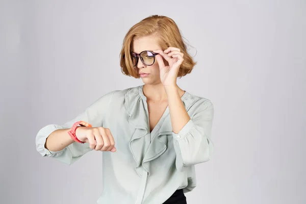 Mulher na moda com um relógio rosa na mão em um fundo leve — Fotografia de Stock