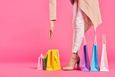 Alışveriş torbaları ayakkabılı kadın ayakları Alışveriş kolik pembe arka plan