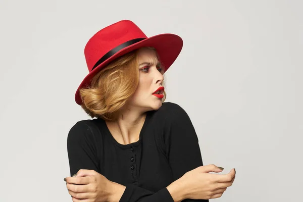 Fashionable woman in red hat black blouse red lips cropped view light background emotions — Stock Photo, Image