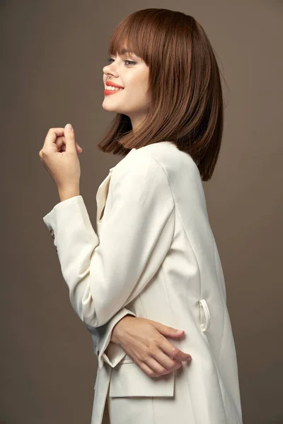 Modelo bonito no vestido pose para a câmera bege fundo — Fotografia de Stock