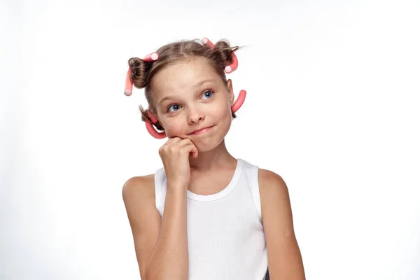 Ein Mädchen in einem weißen T-Shirt wirbelte Lockenwickler Frisur für Haarpflege hellen Hintergrund — Stockfoto