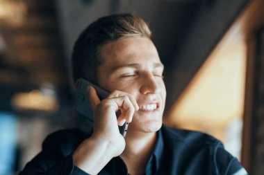 Masadaki kafede cep telefonu olan bir işadamı.