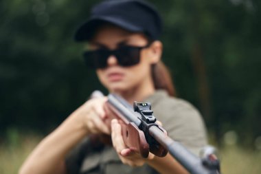 Kadın elinde av tüfeği, görüş, hedef yeşil yapraklar. 