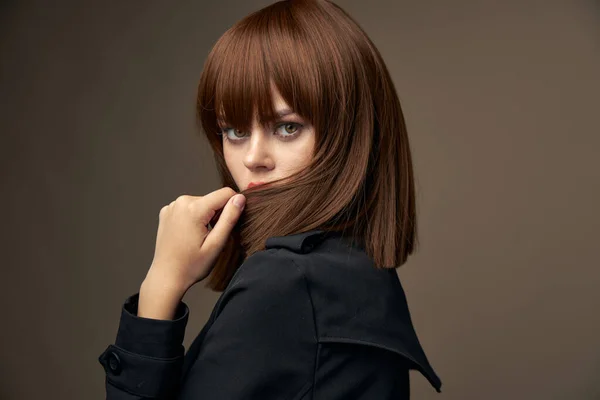Smyslná brunetka evropský vzhled černý kabát oříznutý pohled — Stock fotografie