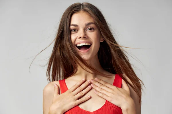 Mujer feliz sostiene sus manos sobre su pecho y se ríe con la boca abierta — Foto de Stock