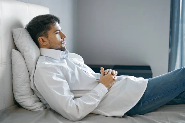Mand ligger på sengen depression Søvnløshed utilfredshed - Stock-foto