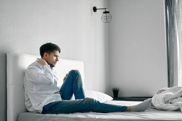 Egy férfi ül az ágyon depressziós elégedetlenség magány — Stock Fotó