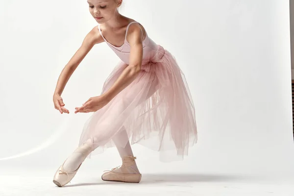 Bailarina de niña en traje de baile rosa baile de ballet puntas zapatos tutú luz fondo modelo — Foto de Stock