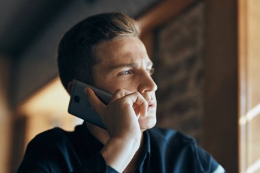 Masadaki kafede cep telefonu olan bir işadamı.