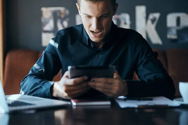 Homme d'affaires pigiste avec ordinateur portable dans un café au gestionnaire de table documents tasse de café modèle — Photo