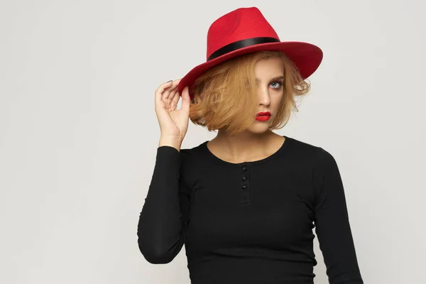 La mujer a la moda en rojo sombrero negro blusa rojo labios recortados ver luz fondo emociones — Foto de Stock