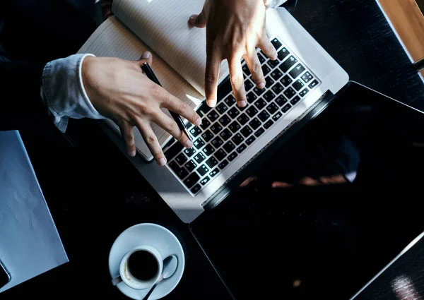 Uomo d'affari seduto in un caffè di fronte a un computer portatile documenti tazza di caffè esecutivo vista dall'alto tecnologia stile di vita — Foto Stock