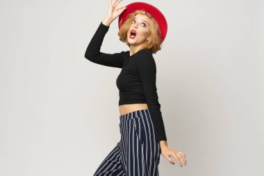 Kırmızı şapkalı şık bir kadın. Siyah bluz. Kırmızı dudaklar.