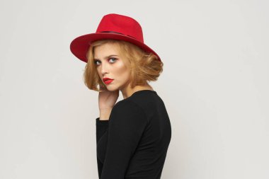 Kırmızı şapkalı şık bir kadın. Siyah bluz. Kırmızı dudaklar.