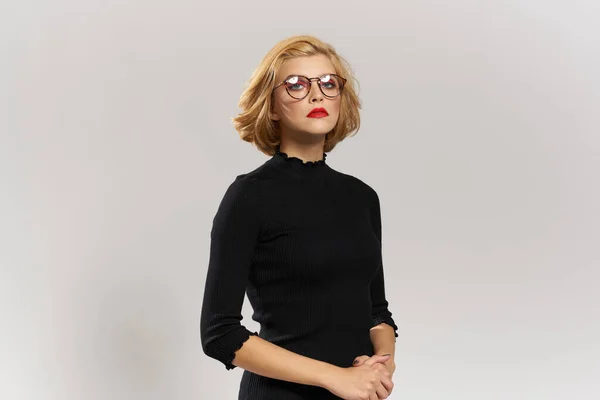 Blonde girl with glasses red lips black blouse cropped view glamor light background studio — Stock Photo, Image