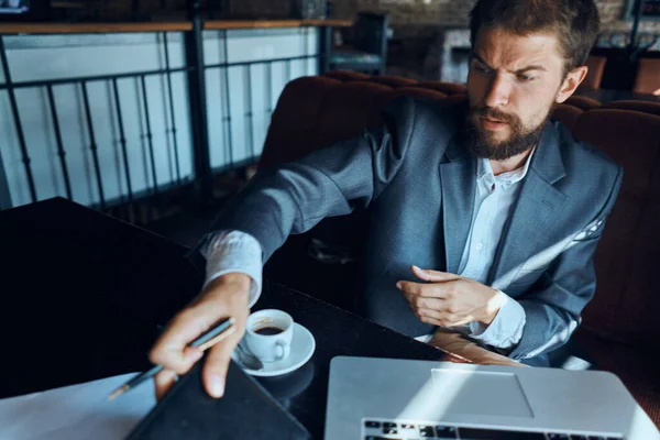 Homme d'affaires assis dans un café devant un ordinateur portable avec une tasse de café style de vie de la technologie de travail — Photo