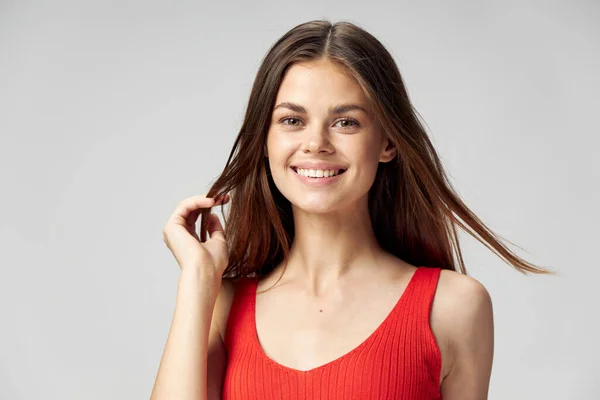 Happy brunetka kobieta uroczy uśmiech czerwony zbiornik top light tło — Zdjęcie stockowe