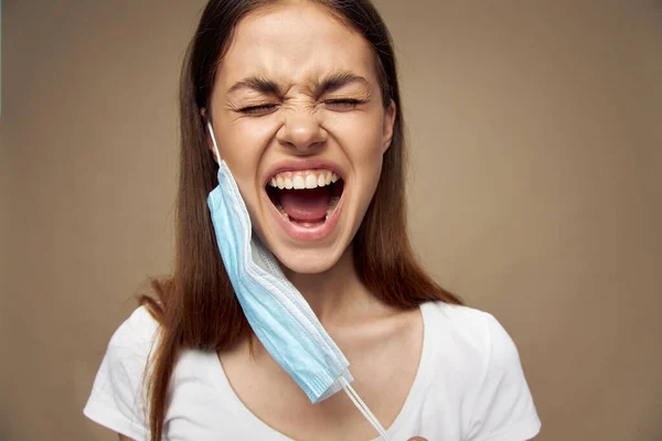 Woman with mask on her ear wide open mouth stress health problems