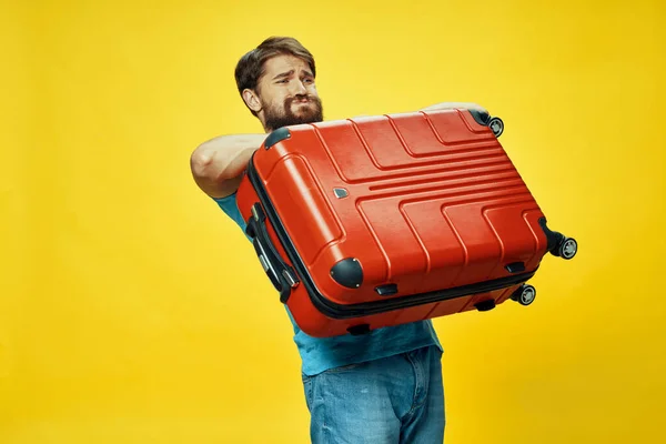 Egy férfi nehéz bőrönddel a kezében utazgat. — Stock Fotó