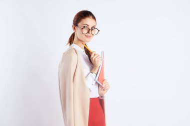 Ellerinde not defteri ve eğitimle mutlu bir bayan öğrenci. Bilim. Açık renk gözlüklü, kırmızı etekli.