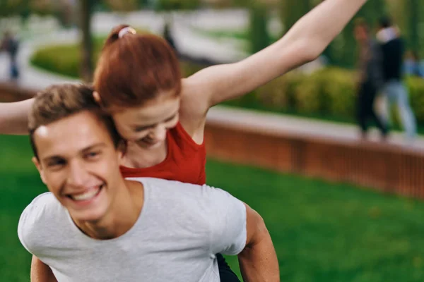 Woman on back men outdoors walk fun lifestyle — Stock Photo, Image